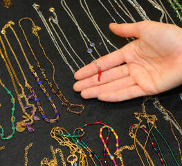 girl s hand is choosing a necklace with a red chili pepper holder in the fashion necklaces and...