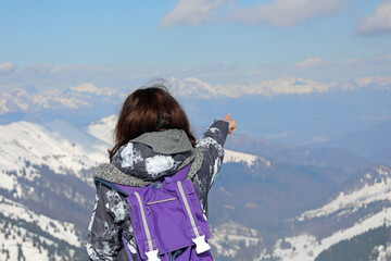 young woman with purple backpack admiring the winter landscape