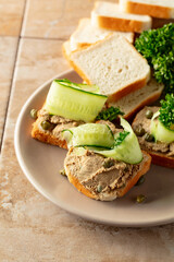 Open sandwiches with pate, cucumber, capers, and parsley. - 783597005