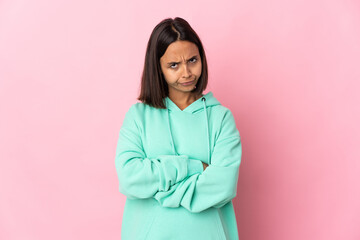 Young latin woman isolated on pink background with unhappy expression