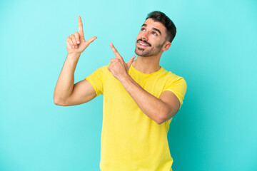 Young caucasian man isolated on blue background pointing with the index finger a great idea