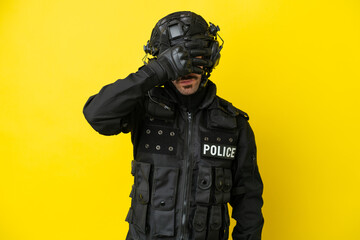 SWAT caucasian man isolated on yellow background covering eyes by hands. Do not want to see...