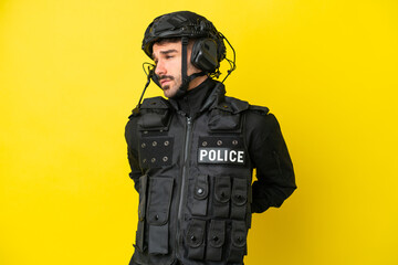 SWAT caucasian man isolated on yellow background suffering from backache for having made an effort