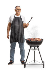 Mature man next to a portable barbecue grill holding a fork