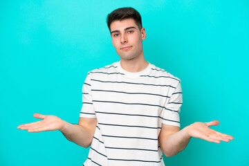 Young caucasian man isolated on blue background having doubts