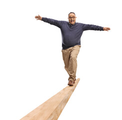 Full length portrait of a mature man walking on a wooden beam