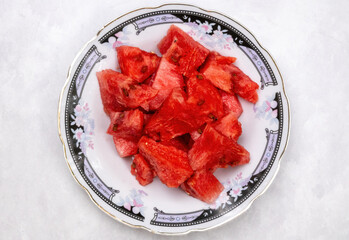 Fresh watermelon slice on a plate on white background. Locally in Bangladesh, it is called Tormuj....
