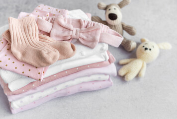 Stack of Baby bodysuits  on a grey background.