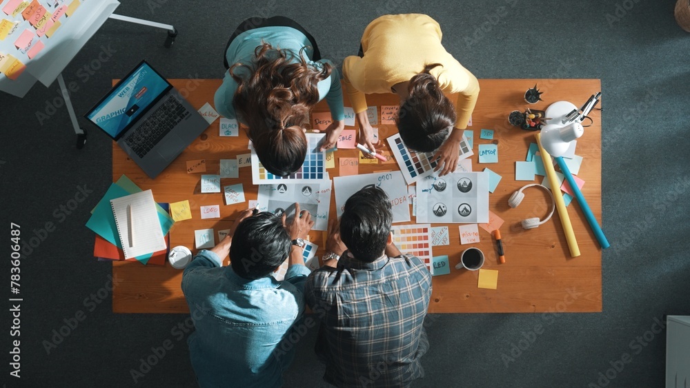 Aufkleber top down aerial view of skilled designer hold logo while discuss with team. aerial business group wo