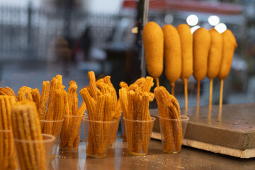 Horizontal photograph of a Mexican snack stand from a retail store where they sell traditional sausage banderillas or skewers and churros from a small business in the market