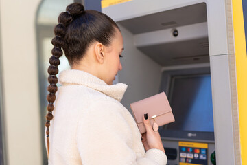 Young moroccan girl  at outdoors using an ATM