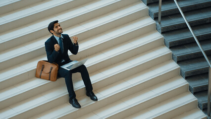 Top view business man celebrate successful project while sitting at stairs. Smart project manager...