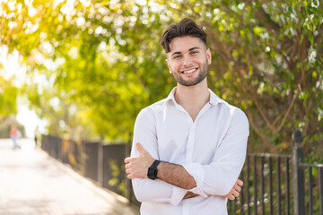 Young handsome man at outdoors keeping the arms crossed in frontal position
