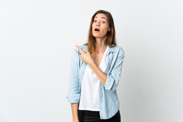 Young Ireland woman isolated on white background surprised and pointing side