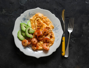 Delicious breakfast, brunch - omelette, shrimp, avocado on a dark background, top view - 783614620
