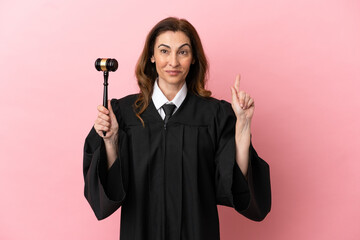 Middle aged judge woman isolated on pink background pointing up a great idea