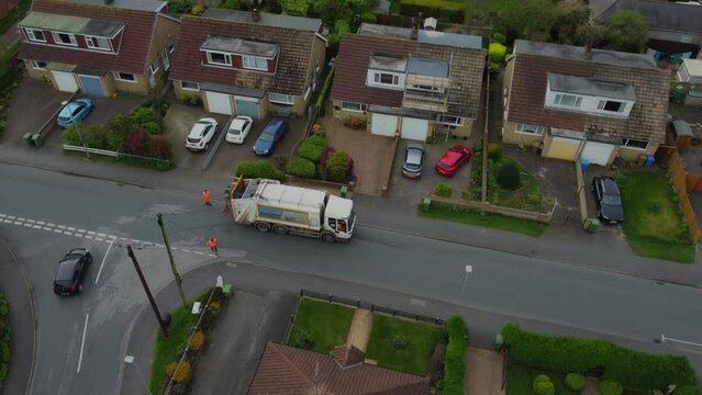 Drone. Waste collection truck in urban street collecting trash. UK	