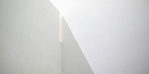 Interior shot of a bright white corner of an indoor place for background or wallpaper.