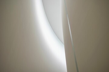 Low-angle shot of a curved modern building ceiling interior with bright white LED lights. - obrazy, fototapety, plakaty