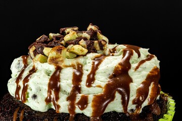 Closeup shot of a homemade baked cupcake placed on a black reflective surface
