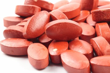 Closeup shot of red vitamins on a white background.