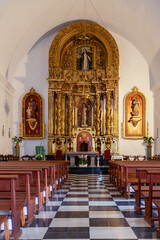 Fototapeta na wymiar The vertical frame captures the opulent golden altar of Puig de Missa church in Santa Eulalia, Ibiza, surrounded by intricately carved religious figures