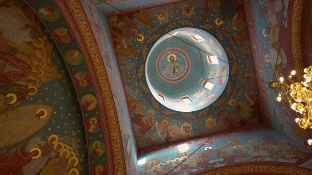 Low angle of the interior and the dome of a church with murals of saints
