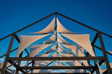 Metal structure with white canvas on a clear blue sky background