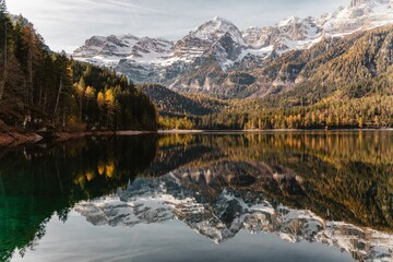 View of the lake and the reflection of trees of the mountains on the water.