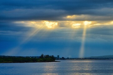 Naklejka na ściany i meble Sunset at the bay of Matanzas, Cuba, the slanting rays shining through clouds and the skyline