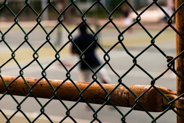 Selective focus of an Old rusty fence by a tennis court