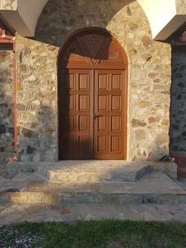 Vertical shot of an old wooden carved door at the entrance of a building
