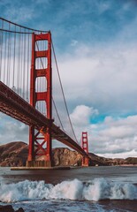 Vertical shot of the Golden Gate Bridge with the splashing waves