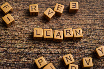 Concept of Learn message written on wooden blocks. Cross processed image on Wooden Background