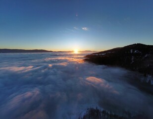 Fototapeta premium Scenic view of the mountain peak covered with snow and trees above the sky