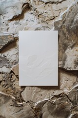 A blank page resting against a backdrop of rugged, earthy stone.