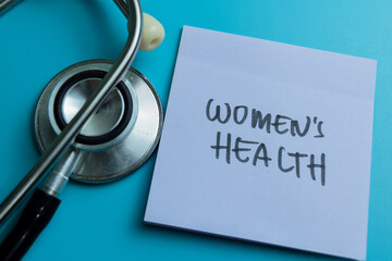 Concept of Women's Health write on sticky notes isolated on Wooden Table.
