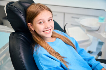 Smiling girl sitting in a dental chair