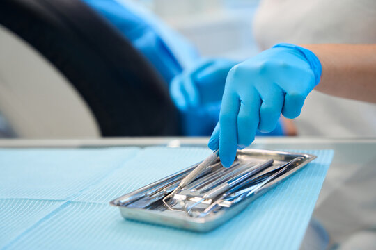 Dentist at workplace using sterile instruments