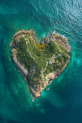 A heart shaped island surrounded by the vast ocean. - obrazy, fototapety, plakaty
