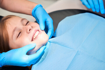 Smiling girl is placed in a chair for dental procedures