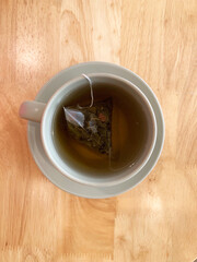 hot drink milk tea leaf bag, milo , kopi coffee mocha with milk in traditional cup and tea spoon and small plate on wood table color vegan healthy restaurant beverage cafe halal food menu