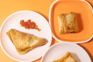 Indian snacks - Crispy vegetable puff on orange background