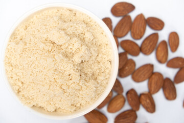 Almond flour and almonds on a white background
