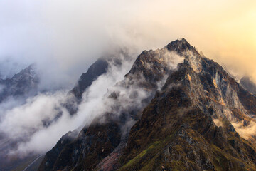 Sunset close to the settlement of Khambachen (aka Khangpachen or Kambachen) with dramatic mountain in the clouds in the Kanchenjunga region in the Himalaya, Nepal on Kanchenjunga Base Camp trek  - 783681247