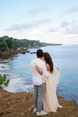 Amidst tropical beauty, the bride and groom hug