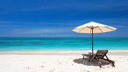 A beach chair reclined under a parasol at a beautiful tropical beach