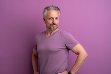 Obraz premium A man in a purple shirt stands in front of a purple wall