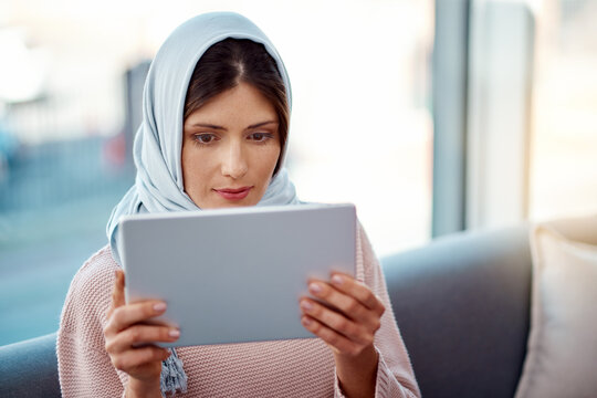 Relax, tablet and muslim woman on sofa in living room streaming movie, film or show for entertainment at home. Rest, digital technology and islamic female person watching video online at apartment.