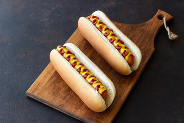 Hot dogs with grilled sausages, ketchup and mustard. Fast food.